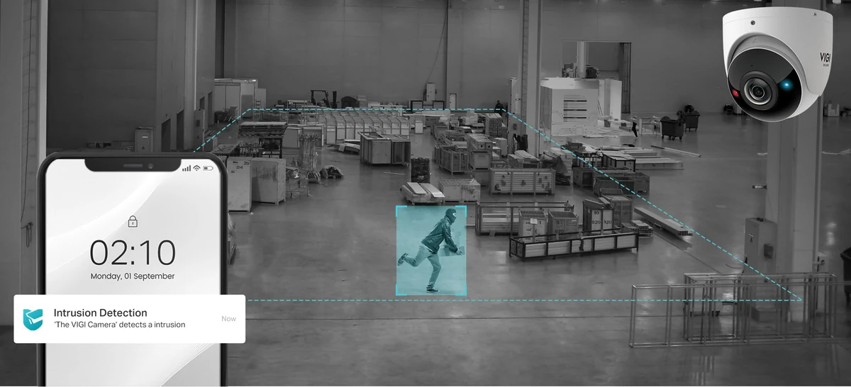 Magazijn in zwart-wit met een persoon in een blauw kader en de camera in beeld; een telefoon toont de melding Intrusion Detection