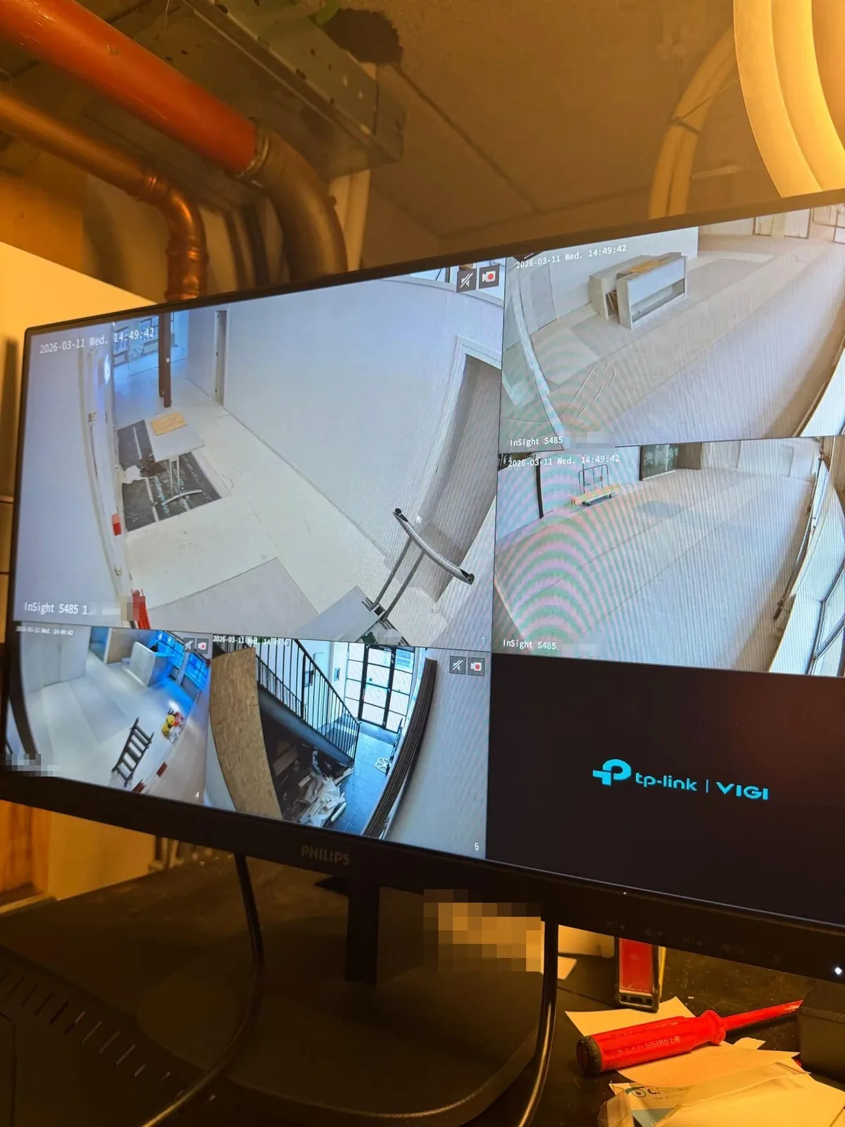 Monitor met vier camerabeelden uit het pand en het VIGI-scherm, in de technische ruimte